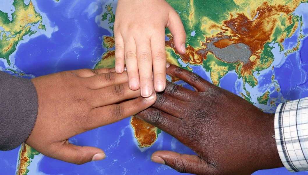 Kinderhände, liegend auf Weltkarte