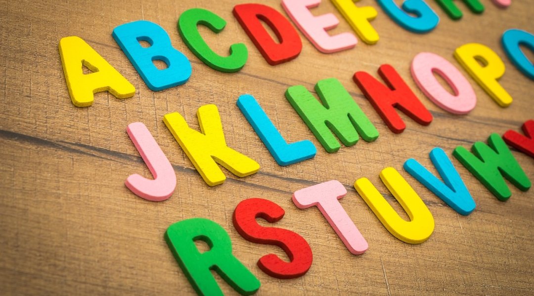 bunte Buchstaben in Filz ABC auf Tisch