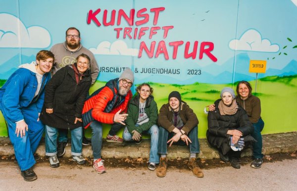 Gruppe junger Künstelr sitzend vor Graffitiwand, Kunst trifft Natur, in Seefeld