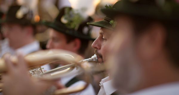 Blasmusiker mit Trompete und Trachtenhut zu sehen, im Profil